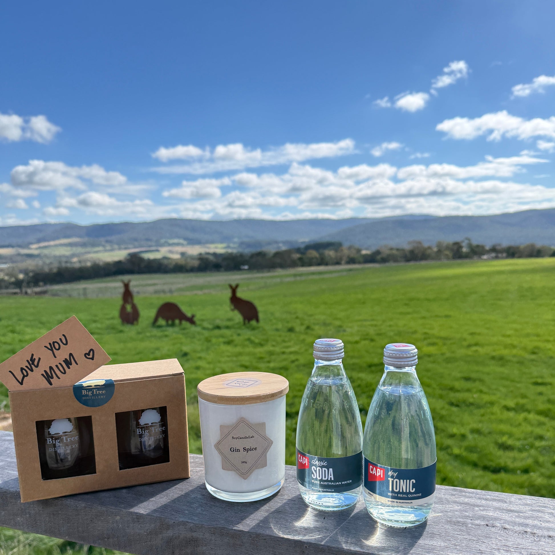 Two bottles of soda and tonic water with a scenic background of kangaroos and a grassy field.